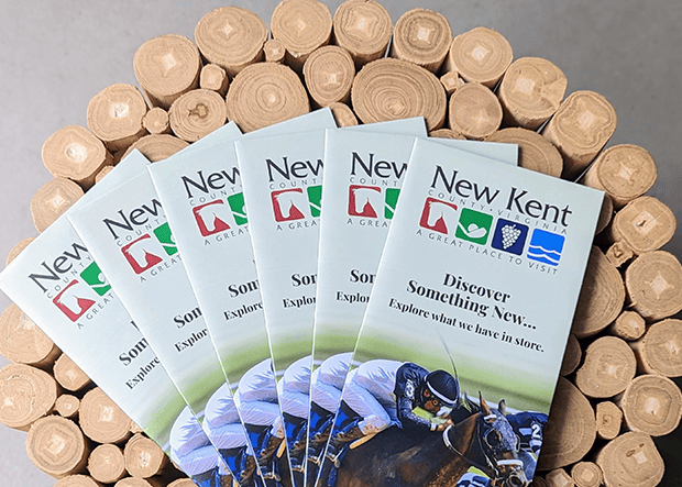 New Kent County tourism brochures arranged on a wooden end table