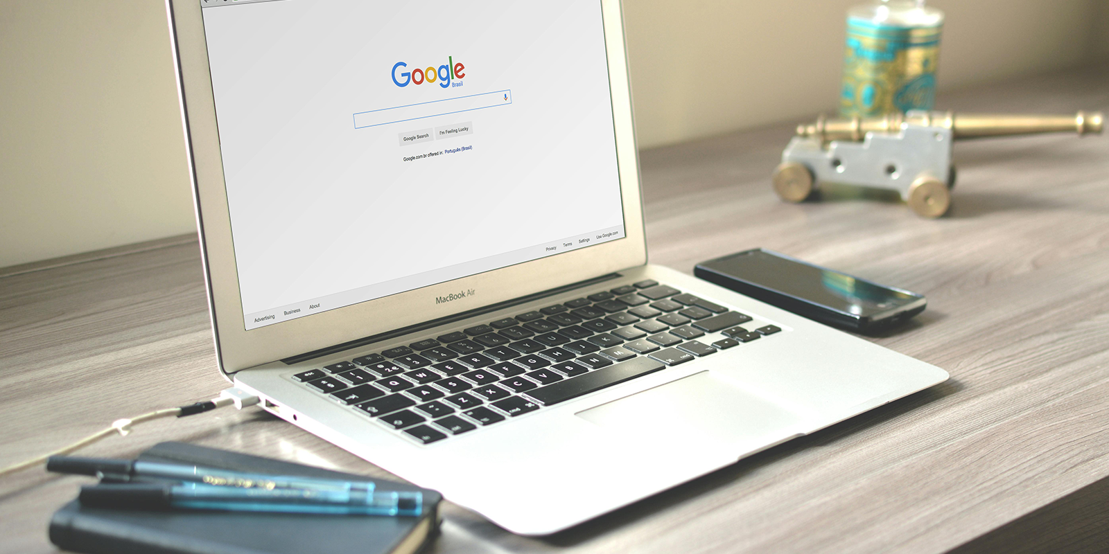 a desk with an open laptop displaying the Google homepage.