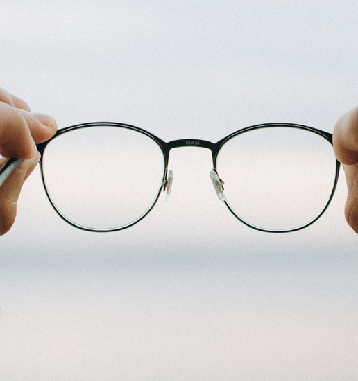 hands holding out a set of eyeglasses